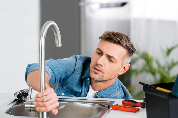 image of a homeowner repairing a faucet
