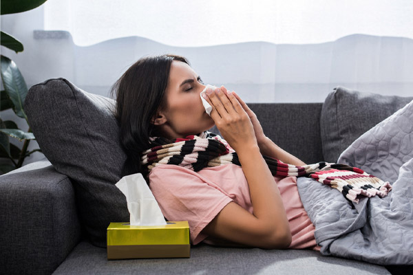 woman sneezing due to poor indoor air quality