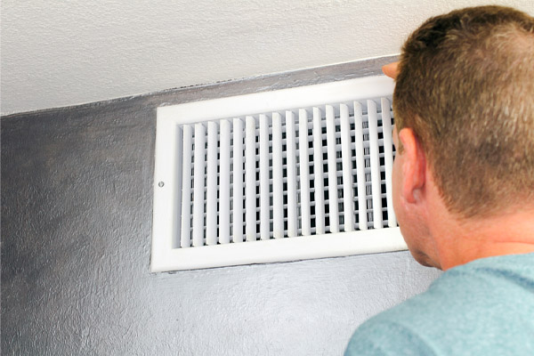 Man Looking in an HVAC Air Vent