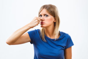 image of a homeowner plugging nose due strong sewer odor in house