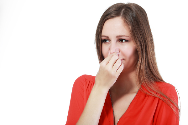 image of a homeowner plugging nose due to dead animal in hvac ductwork