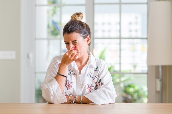 image of homeowner plugging nose due to bad air conditioner smell