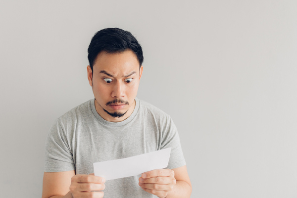 image of a homeowner looking at energy bill in shock due to ac unit inefficiency