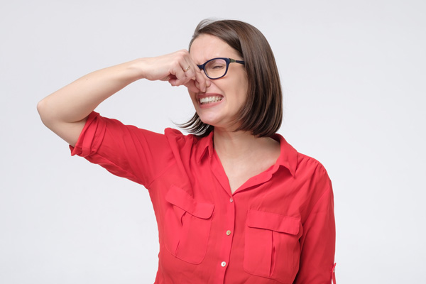 woman plugging nose due to smelly furnace