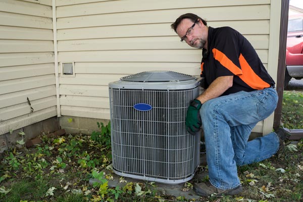 hvac contractor repairing an old air conditioner