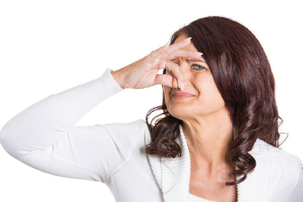 image of a homeowner plugging nose due to a burning furnace odor