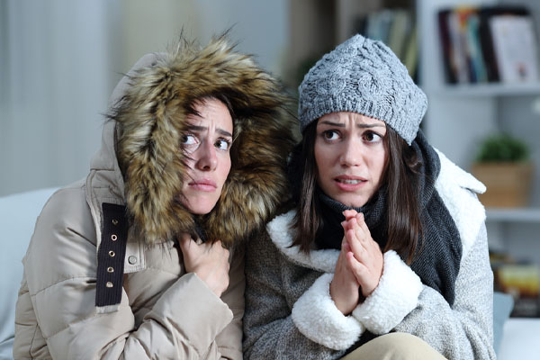 image of a homeowner feeling chilly due to thermostat problems