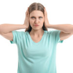 homeowner covering ears due to noisy hvac ductwork