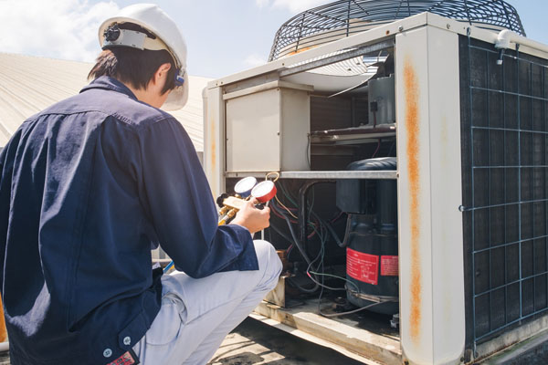 image of an hvac contractor performing an air conditioner maintenance check