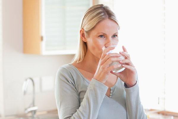 image of homeowner drinking water to avoid dehydration in winter