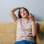 woman suffering from heat at home depicting air balancing and hvac system