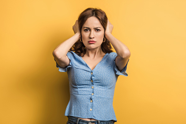 image of homeowner covering ears due to air conditioner noises