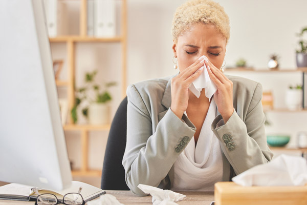 woman sneezing at home due to air quality problems