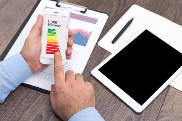 man looking at photo of energy efficiency meter on a smart phone